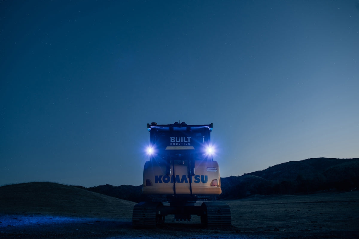 a tractor trailer parked in a field at night